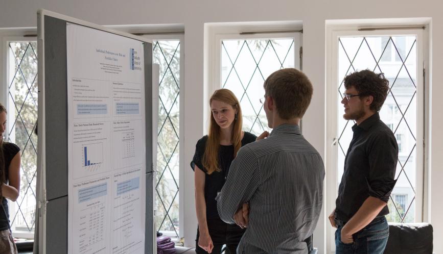 Students look at a student's work during poster sessions.