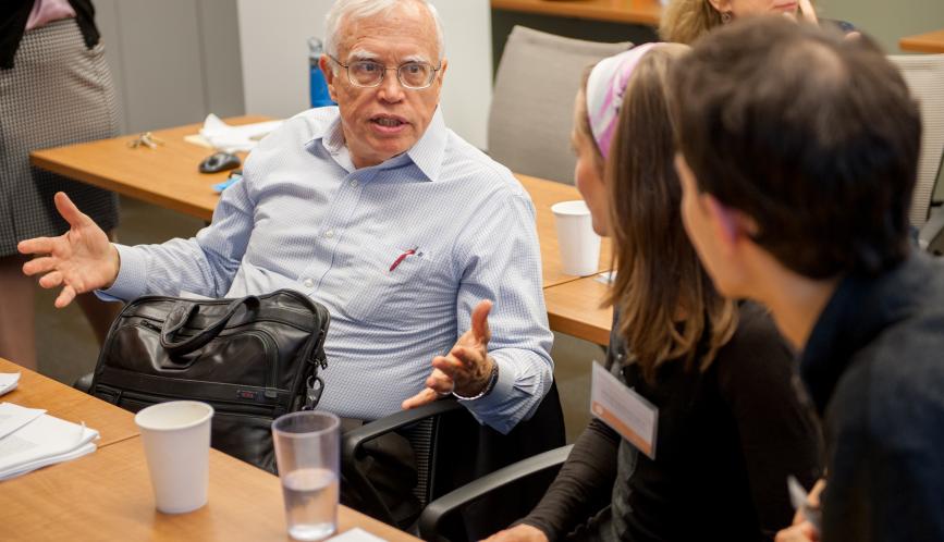 James Heckman, seated, in conversation with conference attendees.