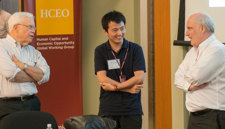 James Heckman, Wei Huang, and Steven Durlauf standing at the front of the classroom.