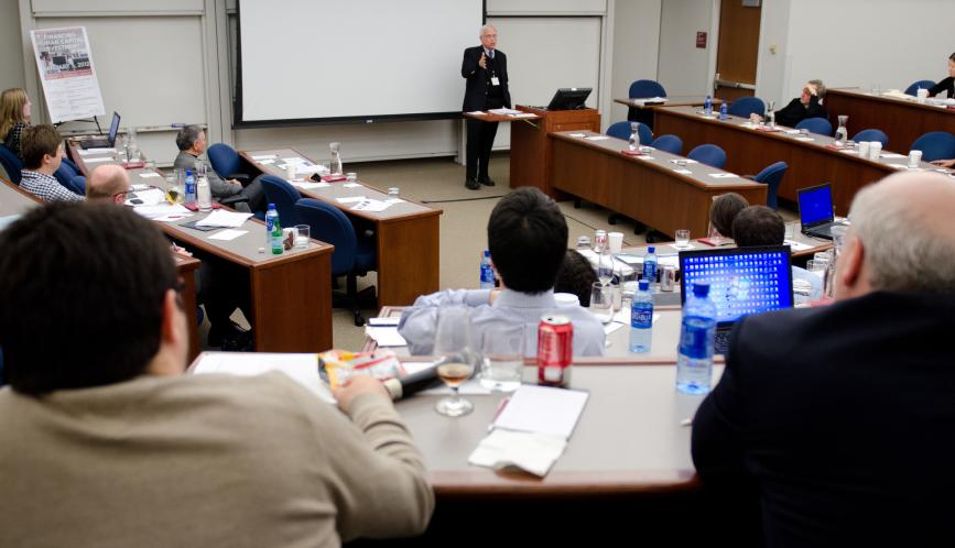A view of the classroom, taken from the rear, while James Heckman speaks at the front of the room.
