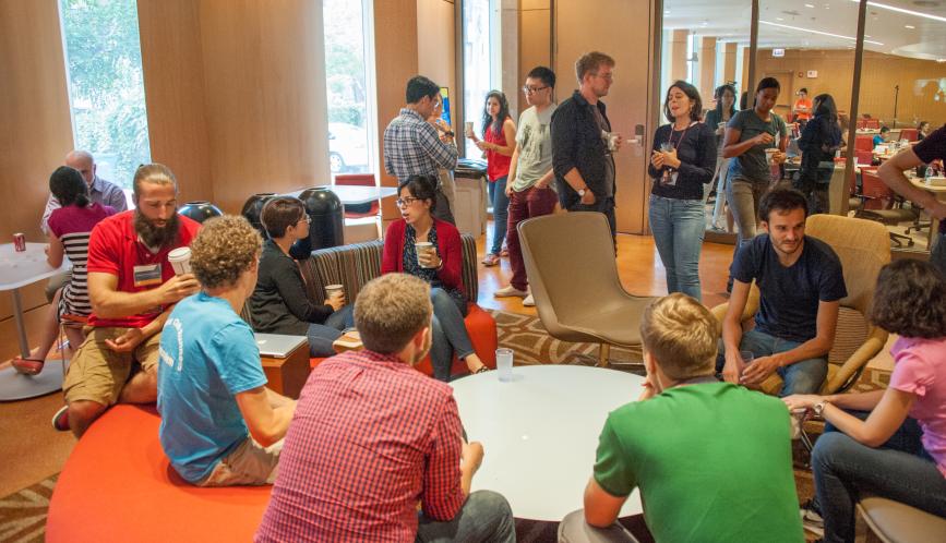 A room of summer school students in conversation during a break.