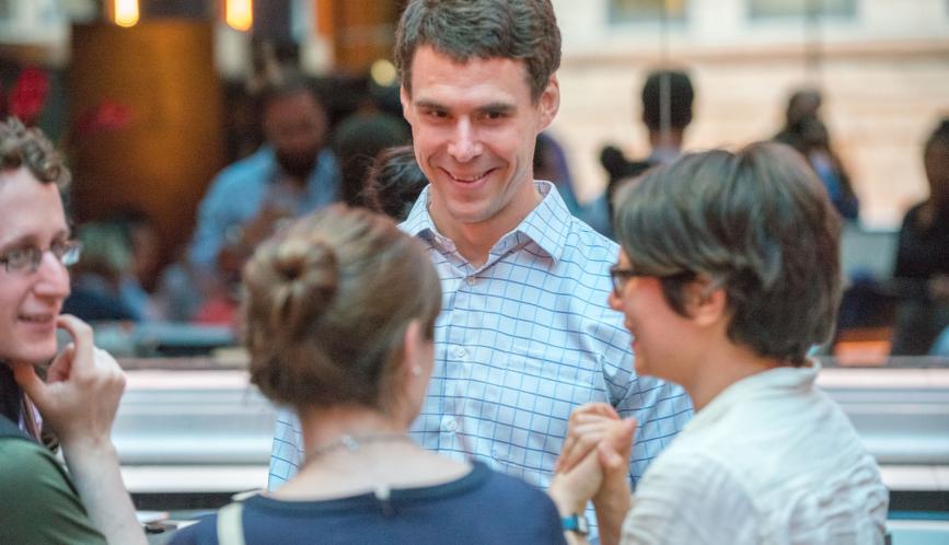 Professor Nathaniel Hendren speaks with summer school students at a group outing.