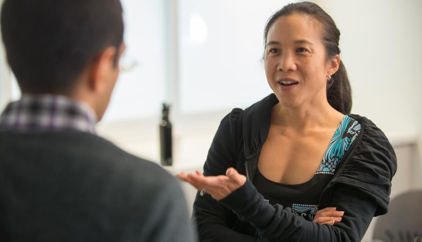 Angela Duckworth speaking with someone who has their back turned to the camera.