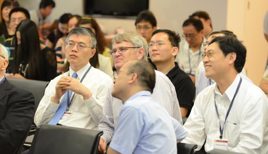 Dali Yang and other attendees listening to a presentation