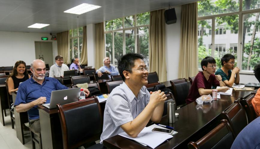 Shuaizhang Feng, smiling, seated at the front of the summer school classroom.