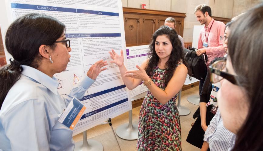 A student presents her work to other students during poster sessions