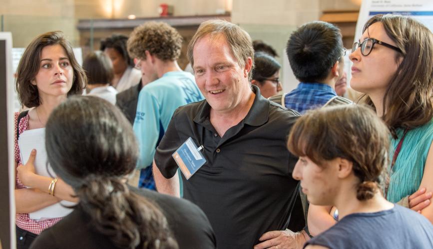 Chris Taber and students listening to a presentation during poster sessions.