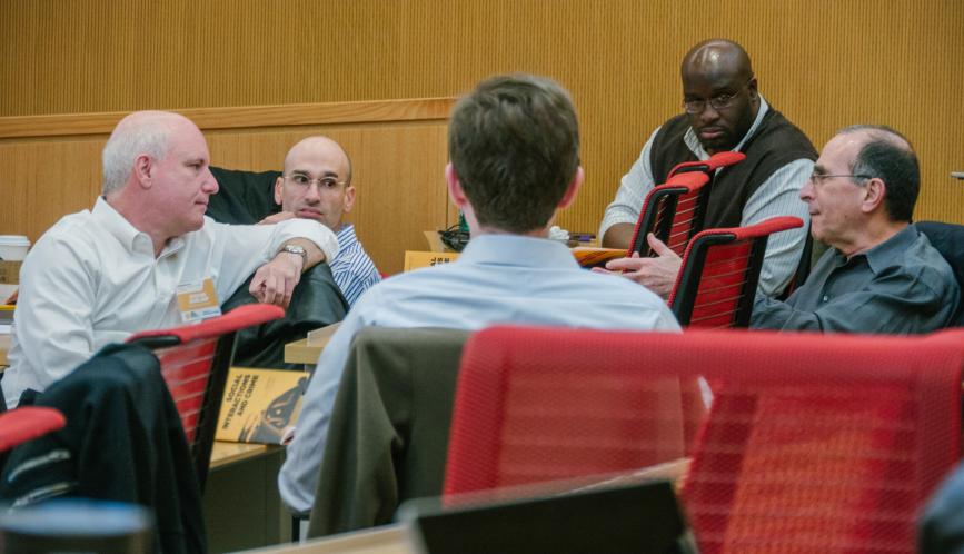 Conference participants in conversation in the classroom.
