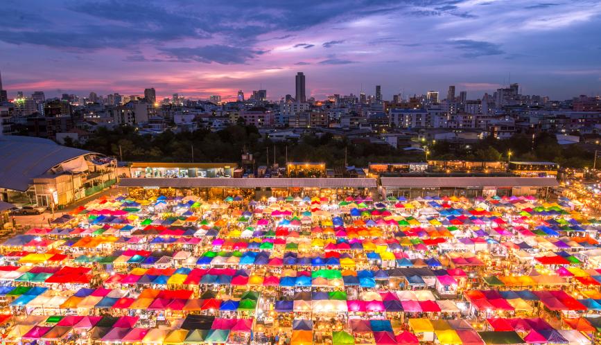 An image of a night market showing illuminated, multi-colored tents.