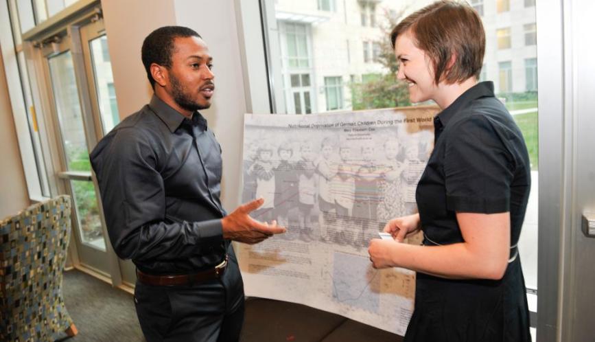 Two students in conversation during poster sessions.