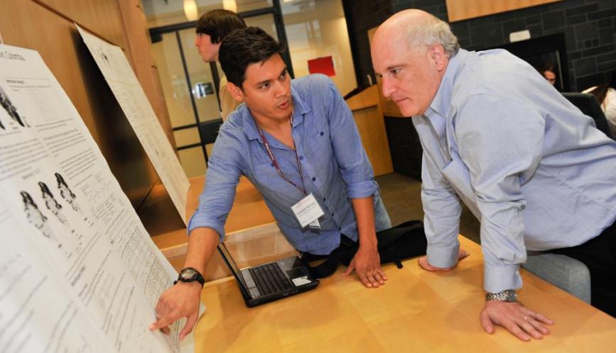 A student explains his work to Steven Durlauf during poster sessions.