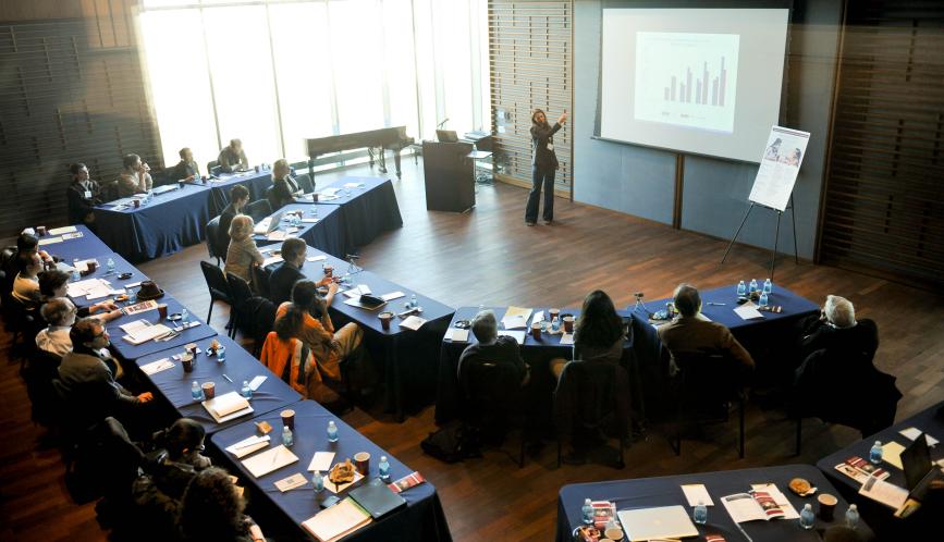Aerial view of the conference room, with attendees watching a lecture.