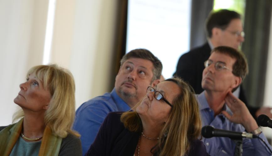 Audience members looking at the presentation on stage