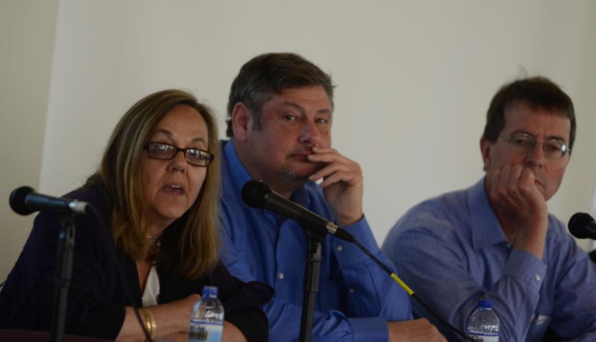 A group of panelists sitting at their microphones