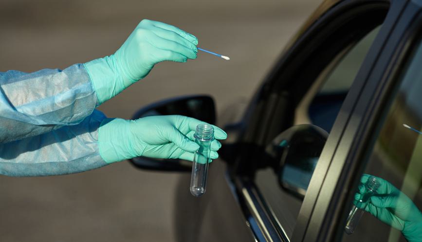 Gloved hands holding cotton swab and test tube in front of a car window.