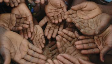A stock image of several children holding open their empty hands.