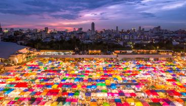 An image of a night market showing illuminated, multi-colored tents.