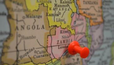 A picture of a map of Zambia, with a red thumbtack stuck into it.