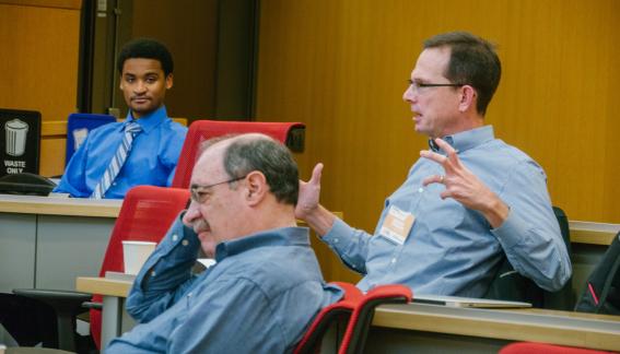 Conference participants in conversation in the classroom.