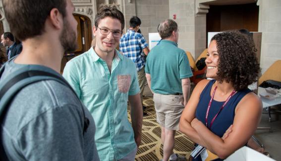 Students stand in conversation during poster sessions.