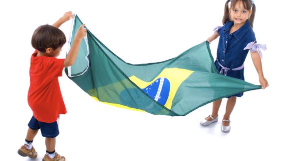 Two young children holding the Flag of Brazil